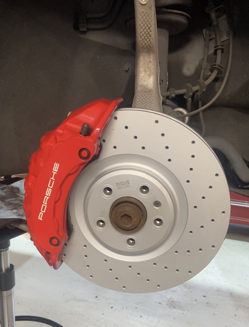 Porsche Macan brake rotor and red Porsche caliper fitted by Prestige Performance Mechanical